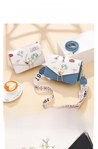Detail of square cross-body bags with Eiffel Tower prints and pearl cat clasp closure