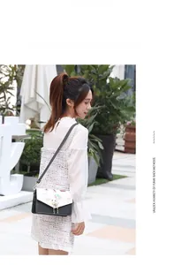 Chic monochrome crossbody bag with hot air balloon print shown on a female model