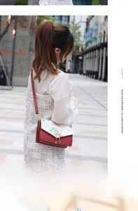 Fashionable red and white crossbody bag featuring cartoon prints and pearl charms