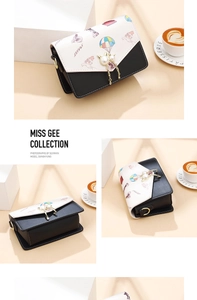Close-up of black and white square bag with colorful world map print and gold cat charm