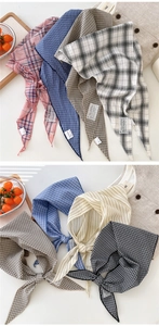Detail of 100% cotton plaid triangle scarves showing fabric texture and variety of patterns