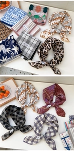 Dettaglio foulard in cotone e lino stampato con motivo leopardato ed etichetta moda