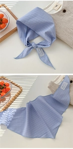 Detail of blue plaid cotton neckerchief showing texture and white lace brand label