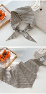 Detailed view of checkered cotton linen scarf with embroidered label and decorative lace