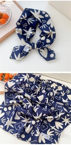 Dettaglio di sciarpa in cotone e lino blu navy con stampe bianche e bordo in pizzo