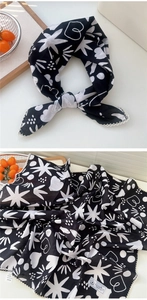 Dettaglio di foulard in cotone con motivi a stelle bianco e nero e bordo in pizzo