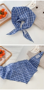 Detail of blue plaid cotton scarf with white lace trim tag and woven fabric texture