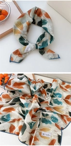 Dettaglio di un foulard in cotone e lino con stampa a foglie e bordo smerlato blu