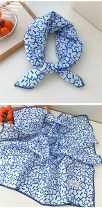 Dettaglio di un foulard quadrato in cotone e lino con fiori blu e bordi cuciti finemente