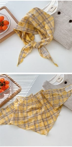 Detail of yellow plaid cotton linen scarf with distressed texture and lace label tag