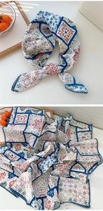 Dettaglio del foulard in cotone a fiori blu con motivi rossi e bordo in pizzo scuro