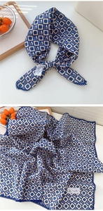 Dettaglio del foulard in cotone blu e beige con motivi floreali e bordi all'uncinetto