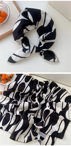 Dettaglio di un foulard geometrico bianco e nero con eleganti bordi in pizzo bianco