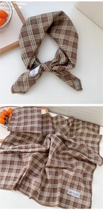 Dettaglio di sciarpa in cotone e lino a quadri marroni e beige con bordo in pizzo