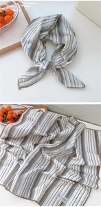 Dettaglio di sciarpa in lino etnico con motivi geometrici e bordi all'uncinetto marroni