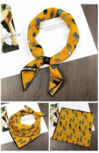 Detail of yellow printed square scarf with a black leather slide buckle and cartoon art