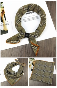 Detail of checkered silk scarf with orange rolled edges and a leather metal ring buckle