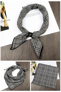 Detail of houndscarf with black and white plaid pattern and a black leather loop fastener