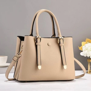 Dettaglio borsa tote beige in pelle martellata con finiture dorate e tracolla