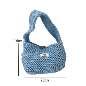 Detail view of light blue knit tote bag showing thick texture and brand label