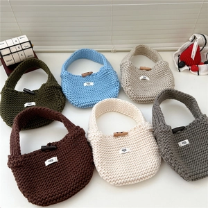 Minimalist knit tote bags in various colors featuring button closures and woven textures