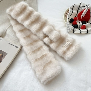 Detail of soft beige plush scarf featuring wavy faux fur texture and brand label