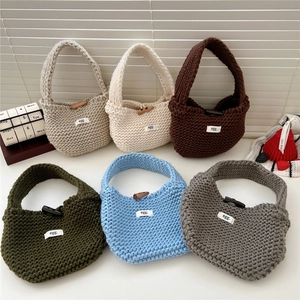 Collection of small knitted tote bags in neutral colors with wooden button closure