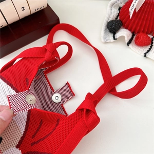 Close-up of red knitted handbag showing secure metal magnetic buckle and thick texture