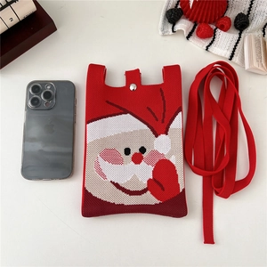 Macro detail of red knitted phone bag with Santa Claus pattern and metal snap button