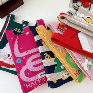 Close-up of festive knitted mini bags with metal snap buttons and colorful holiday patterns