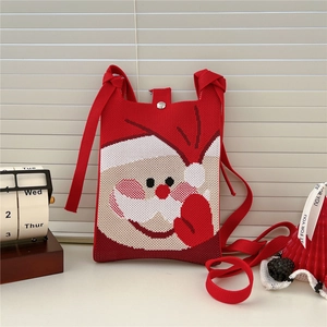 Close-up of red knit Christmas crossbody bag with Santa Claus pattern and metal snap button
