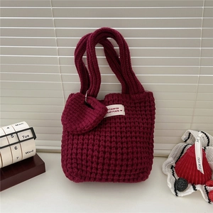 Détail de la maille du sac cabas bordeaux avec breloque coeur et étiquette tissée
