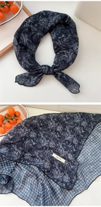 Detail of floral printed cotton linen scarf with fine edge stitching and brand label