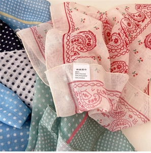 Detail of assorted polka dot and paisley cotton-linen blend scarves with fabric labels