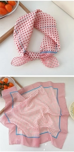 Close-up of a red and white polka dot scarf with blue edges tied in a decorative bow