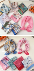 Detailed flat lay of printed cotton-linen square scarves with floral and animal patterns