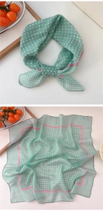 Detail of light green polka dot scarf with pink striped edges and silky texture