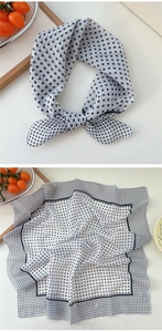 Close-up of black polka dot cotton-linen neckerchief with classic French style striped edge