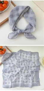 Detailed close-up of grey and white checkered square scarf with high-quality hemmed edges