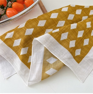 Close-up of yellow and white diamond pattern cotton linen scarf with soft fabric texture
