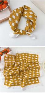 Detail of yellow and white gingham silk scarf showing fabric texture and checkered pattern