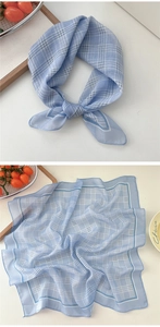 Close-up of light blue checkered cotton linen neckerchief showing fabric texture and drape
