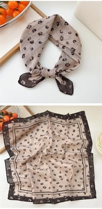 Detail of floral print linen cotton square scarf showing hem edges and knotted styling