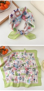 Detail view of square green polka dot scarf with colorful geometric patterns and stitching