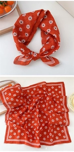 Detail of orange floral cotton linen scarf with white daisy pattern and striped edges