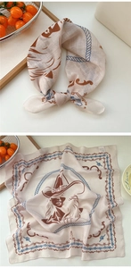 Detail of vintage cowboy print silk scarf with denim hat pattern on cotton linen fabric