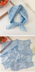 Detail of light blue polka dot cotton scarf with red cherry and paisley floral patterns