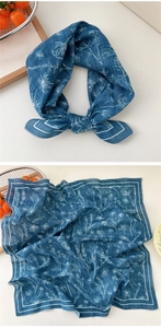 Close-up of blue cotton-linen square scarf with white floral daisy patterns and soft texture