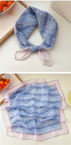 Close-up of leopard dot print cotton-linen scarf with lavender border on a stylish table