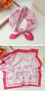 Detail of pink plaid square scarf featuring cute bear and strawberry cartoon patterns